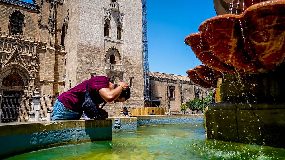 Hitze global: Die Erwärmung des Mittelmeers spüren wir bis in die Schweiz. In Spanien gilt im Juli verbreitet Hitze-Alarmstufe Rot: Ein Tourist kühlt sich in einem Brunnen auf der Plaza Virgen de los Reyes in Sevilla. 