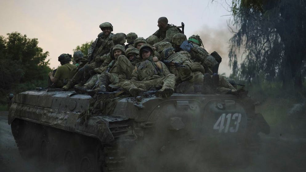 Ukrainische Soldaten fahren auf einem Panzer an die Frontlinie bei Bachmut. 