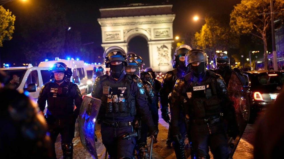Polizisten patrouillieren vor dem Arc de Triomphe auf der Pariser Champs Élysées. Foto: Christophe Ena/AP