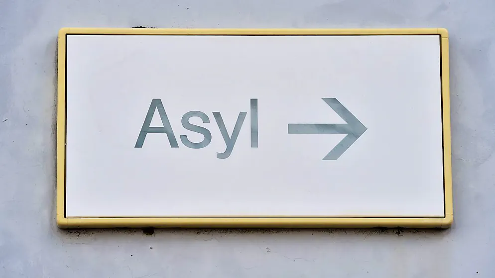 ARCHIV - Ein Schild mit der Aufschrift «Asyl» hängt in der Landeserstaufnahme für Asylbewerber (LEA) an einer Wand. Foto: Uli Deck/dpa