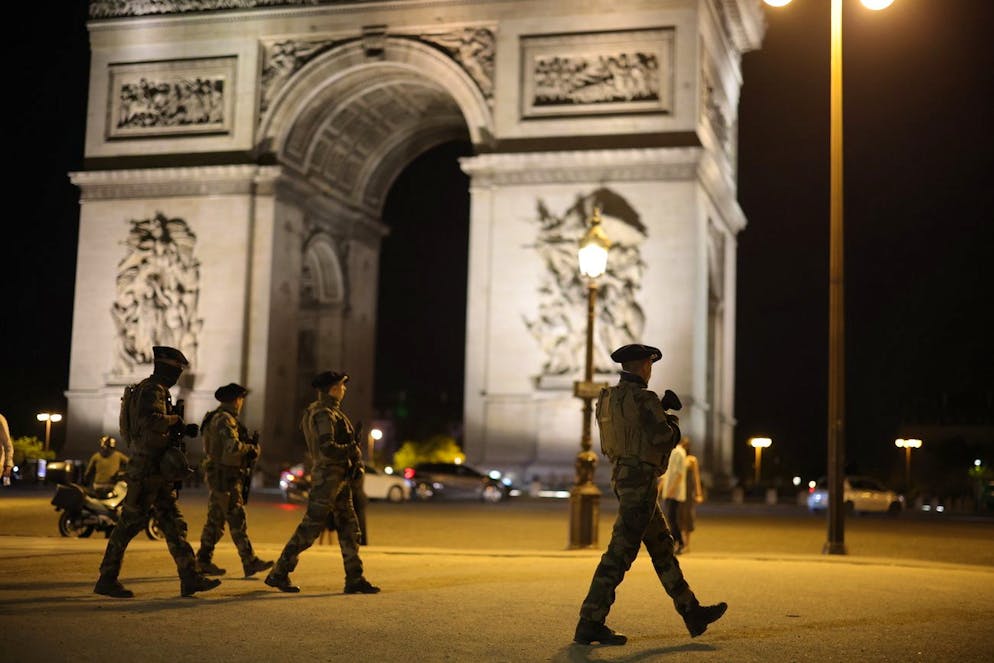 Soldati francesi pattugliano i dintorni dell'Arco di Trionfo, a Parigi, la notte del 2 luglio.