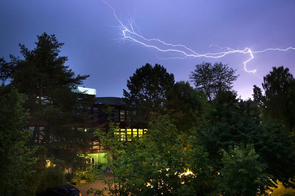 Fulmini durante un temporale sopra l'edificio scolastico del Freie Gymnasium, martedì 11 luglio 2023 a Berna