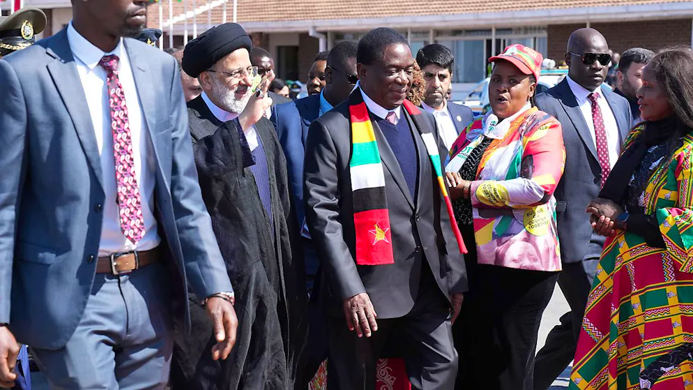 Simbabwes Präsident Emmerson Mnangagwa (M) empfängt Irans Präsidenten Ebrahim Raisi (2.v.l) nach dessen Ankunft in Harare. Foto: Tsvangirayi Mukwazhi/AP/dpa