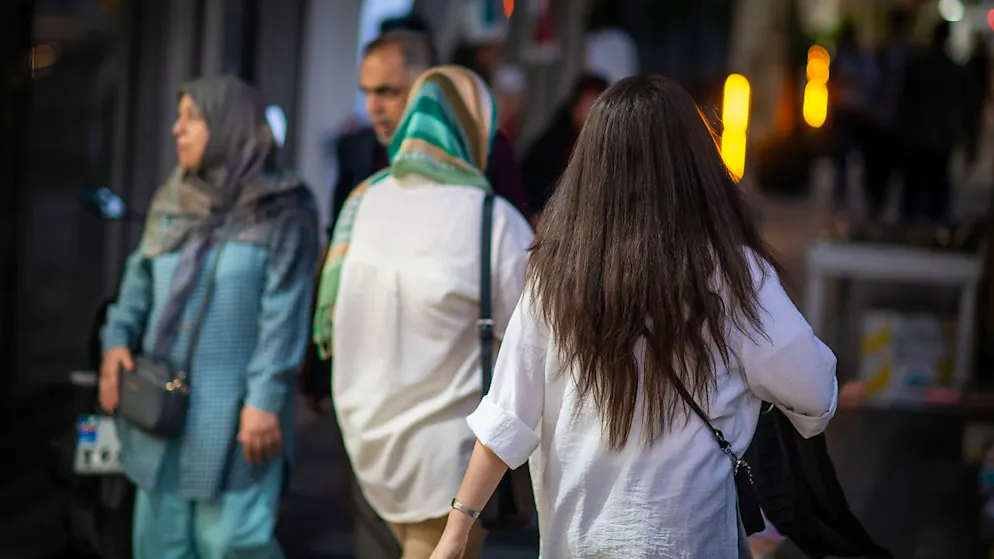 ARCHIV - Eine Frau läuft mit offenen Haaren durch Teheran - ein Dorn im Auge der Regierung. Foto: Arne Bänsch/dpa