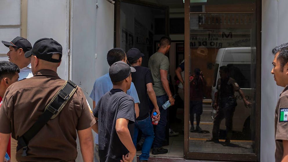 HANDOUT - Migranten, die aus einem abgestellten Lastwagen befreit wurden, werden in ein Büro des mexikanischen Instituts für Migration gebracht. Foto: Felix Marquez/dpa
