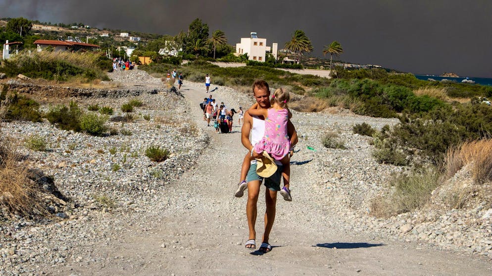 Chaotische Nacht auf Rhodos – Waldbrände toben weiter - Gallery. Menschen verlassen ein Waldbrandgebiet auf Rhodos. Auf der griechischen Insel wüten weiter mehrere Brände.