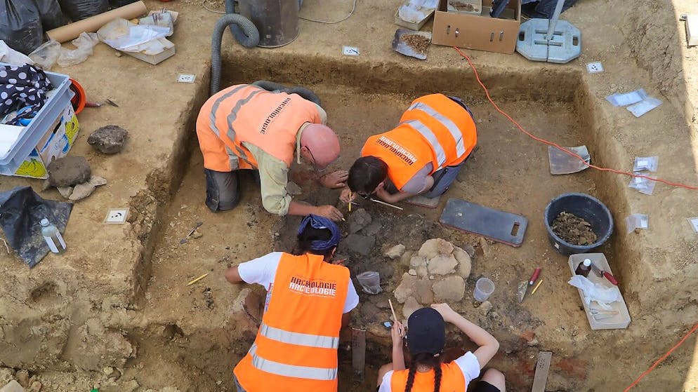 Die Archäologinnen und Archäologen dokumentieren und sichern die Fundstelle in Delley FR.