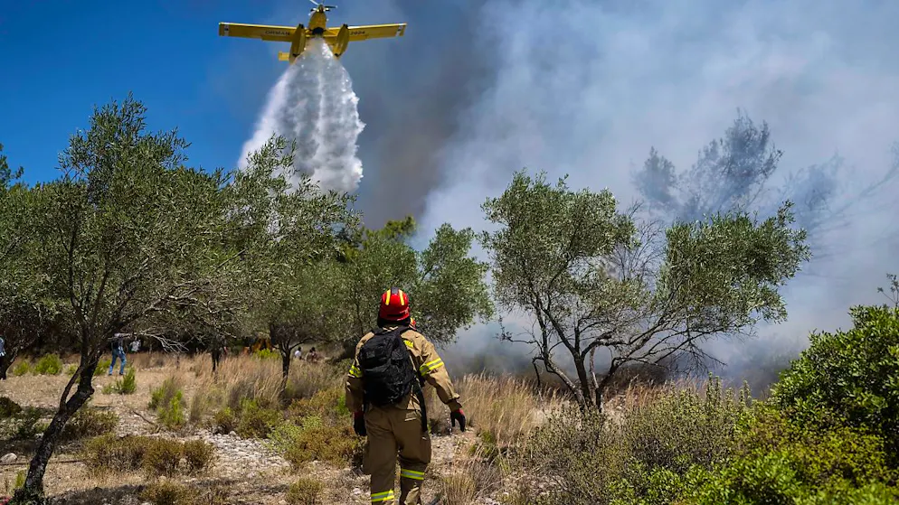 Ein Flugzeug wirft Wasser über einem Waldbrand beim Dorf Vati ab. Auf der Insel Euböa ist bei einem Einsatz ein Löschflugzeug abgestürzt. Foto: Petros Giannakouris/AP/dpa