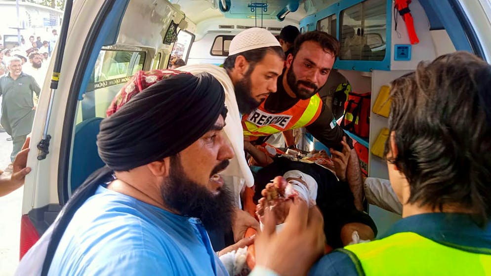 Rettungskräfte tragen einen Verwundeten nach einer Bombenexplosion zu einem Rettungswagen.