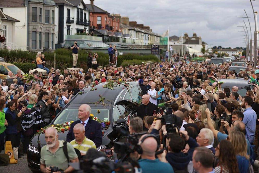 Sängerin in Irland beigesetzt: Tausende Fans trauern um Sinéad O'Connor.. Die Strassen von Bray sind wegen der Beerdigung von Sinéad O'Connor voll. Fans folgen dem Leichenwagen und werfen Blumen auf das Fahrzeug. 