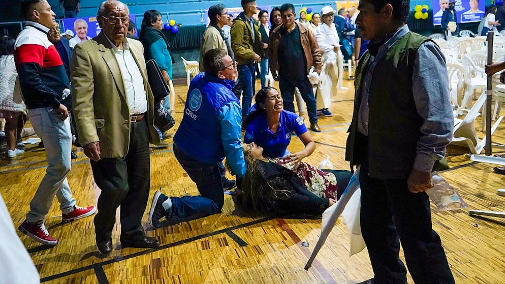 dpatopbilder - Eine Anhängerin des ecuadorianischen Präsidentschaftskandidaten Fernando Villavicencio liegt verwundet auf dem Boden einer Sporthalle, nachdem dort am Ende einer Wahlkampfkundgebung in Quito, Ecuador, geschossen wurde. Villavicencio wurde dort erschossen. Foto: ./API via AP/dpa