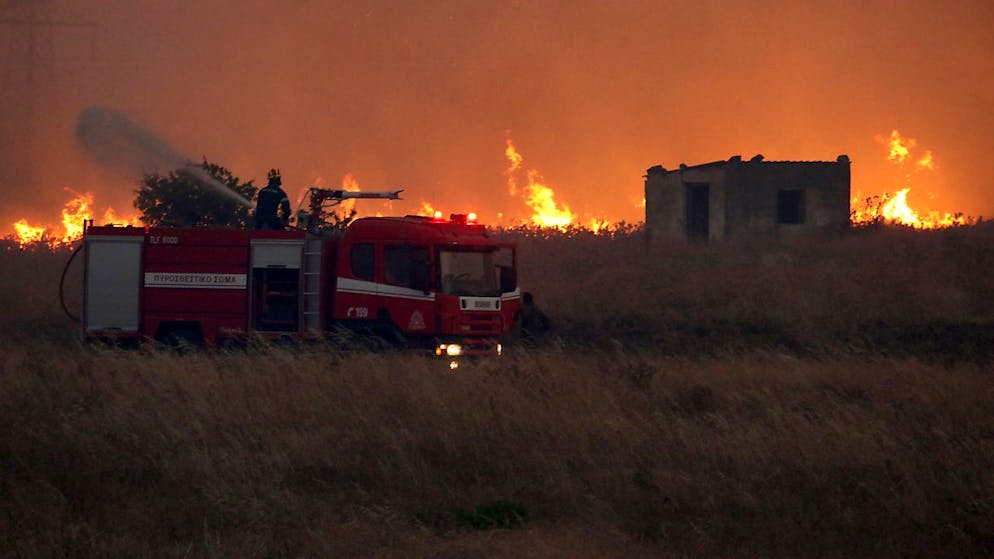 dpatopbilder - Ein Feuerwehrmann versucht einen Waldbrand zu löschen. Foto: Ilias Kotsireas/InTime News/AP/dpa