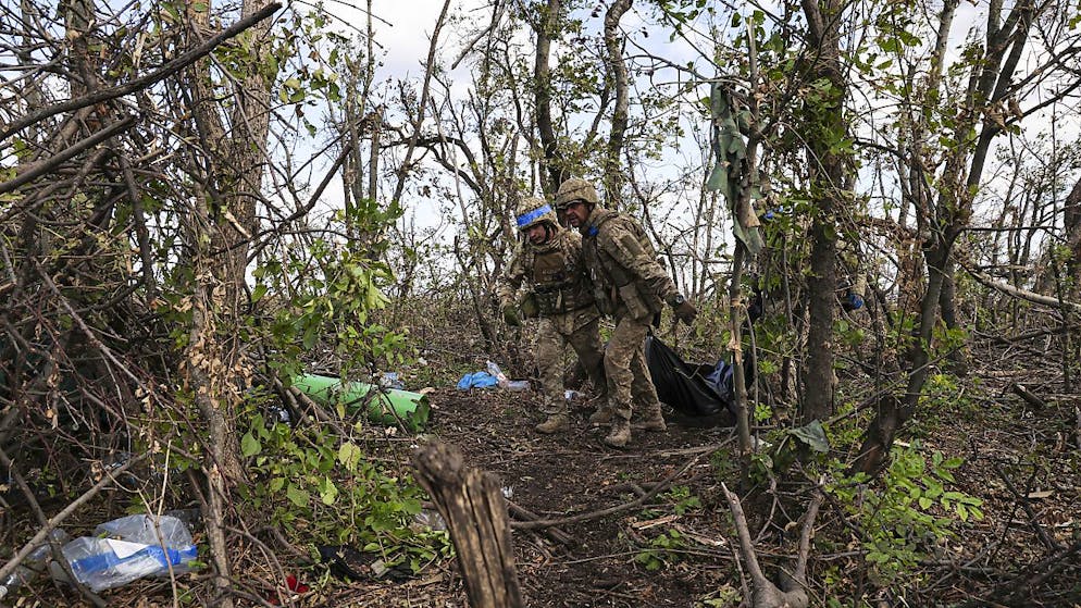 Soldati ucraini trasportano un commilitone caduto, lungo la linea del fronte a pochi chilometri da Andriivka, regione di Donetsk.