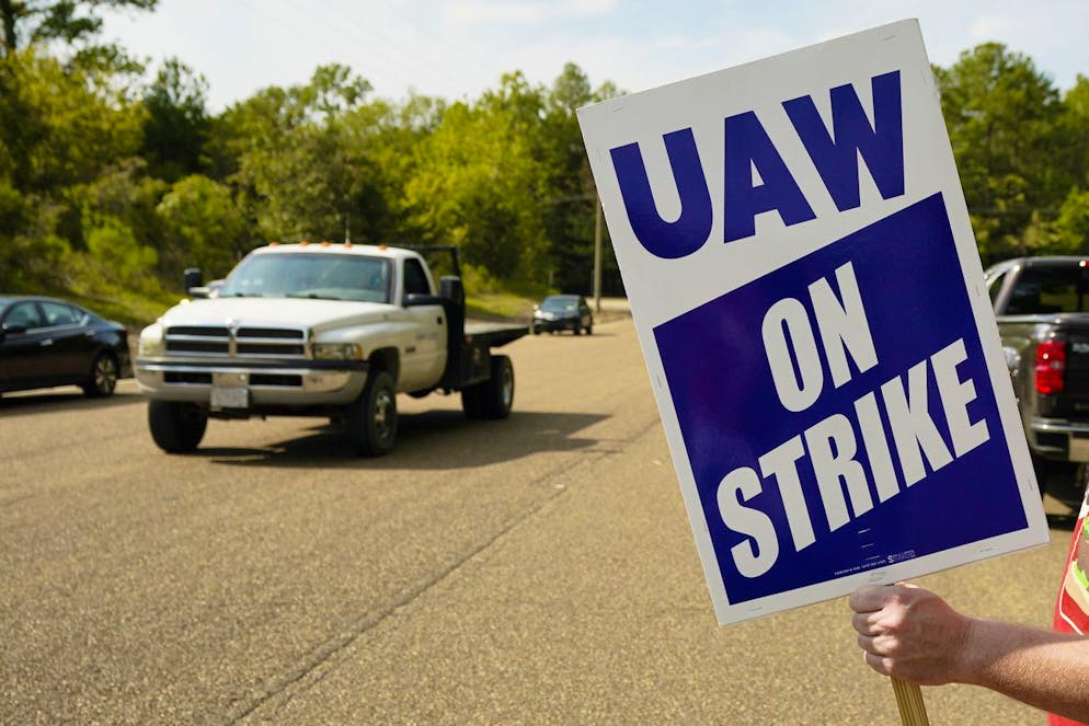 Un membro della UAW Local 2402 (il sindacato del settore auto, ndr) sventola un cartello all'esterno della struttura di assistenza clienti e post-vendita della General Motors a Brandon, Mississipi, venerdì 22 settembre 2023.