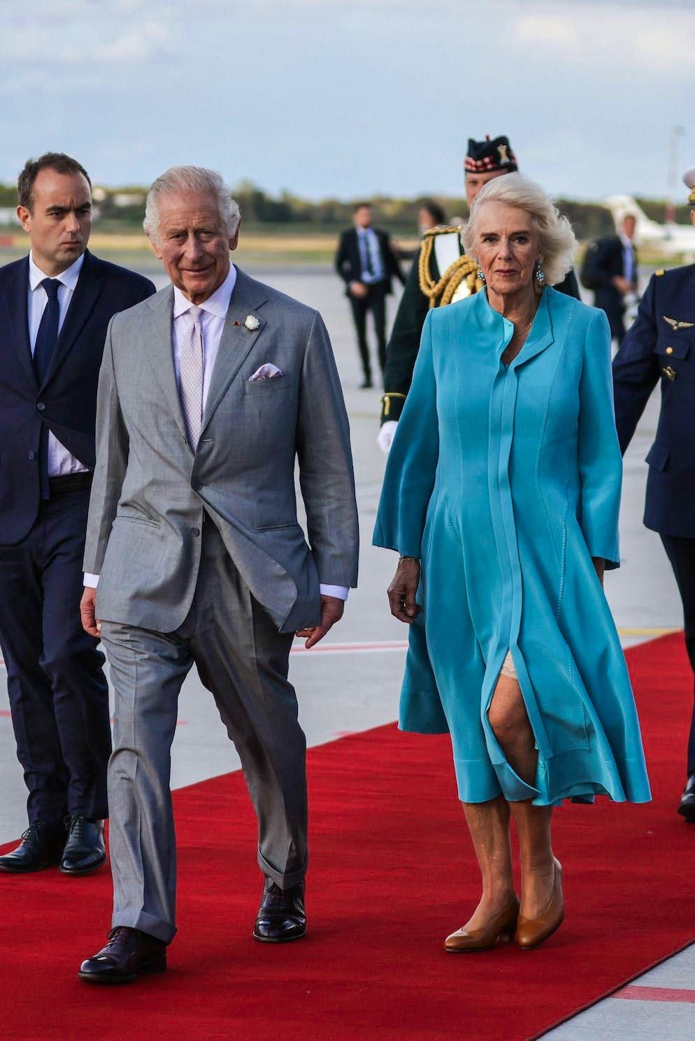 Camilla in Francia. Il vento ha giocato un brutto scherzo a Camilla all'aeroporto. Tuttavia, questo non ha cambiato il fatto che il 22 settembre era molto elegante in un semplice abito a cappotto. Il vestito potrebbe provenire dal guardaroba della principessa Kate, che viene ripetutamente avvistata in capi di questo tipo.