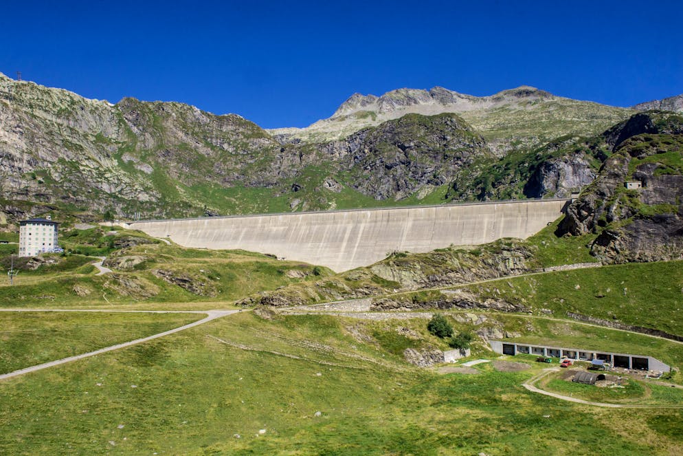 Nella foto la diga di Robiei, in Valle Bavona, inaugurata nel 1967 alta 68 m e lunga 360 serve ad alimentare le Office dell'Ofima. Dietro il massiccio montuoso c'é la Valle Bedretto con All'Acqua, zona da cui partirà la nuova linea ad alta tensione, che passserà proprio in Valle Maggia (di cui la Bavona fa parte) per raggiungere Magadino.