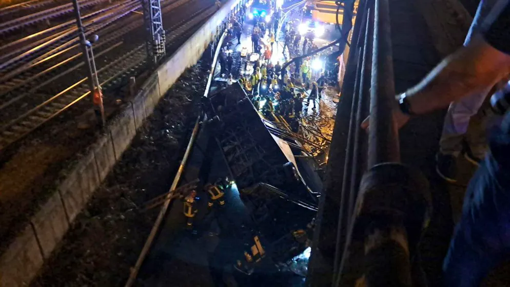 Rettungskräfte arbeiten an der beleuchteten Stelle, an der ein Bus mit Fahrgästen abgestürzt ist.