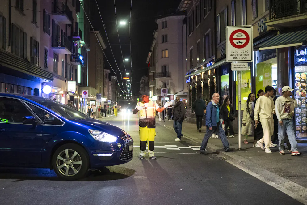 Neues Verkehrsregime an der Zürcher Langstrasse. Ein Mann signalisiert den Autofahrern den Weg um das autofreie Stück Strasse an der Langstrasse in Zuerich, aufgenommen am Samstag, 30. September 2023.