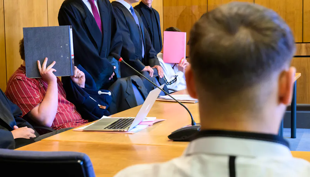 Die mutmasslichen Täter verdecken am 4. Oktober vor dem Landgericht Hildesheim ihr Gesicht.