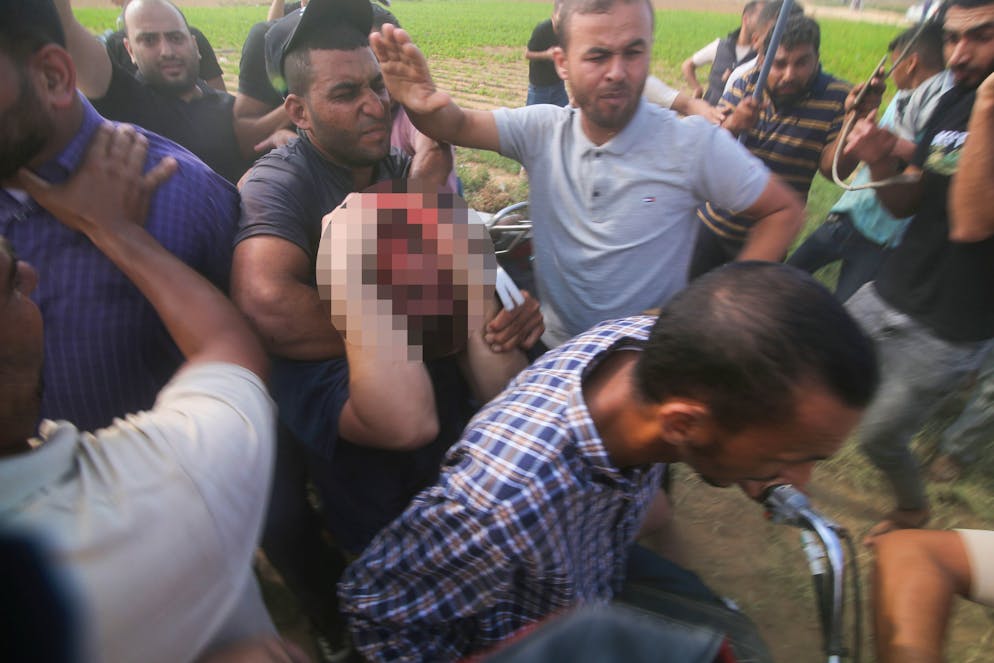 Palästinenser bringen einen gefangenen israelischen Zivilisten (Mitte) aus dem Kibbuz Kfar Azza in den Gazastreifen.