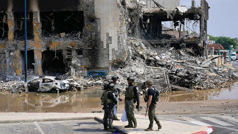 Israelische Polizisten stehen vor einer zerstörten Polizeistation. Foto: Ohad Zwigenberg/AP/dpa
