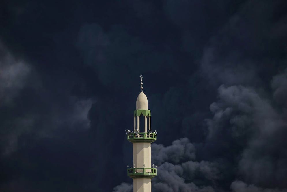 Il fumo si alza dietro un minareto a seguito di un attacco aereo israeliano sul quartiere di Al-Tufah a Gaza City, 11 ottobre 2023.