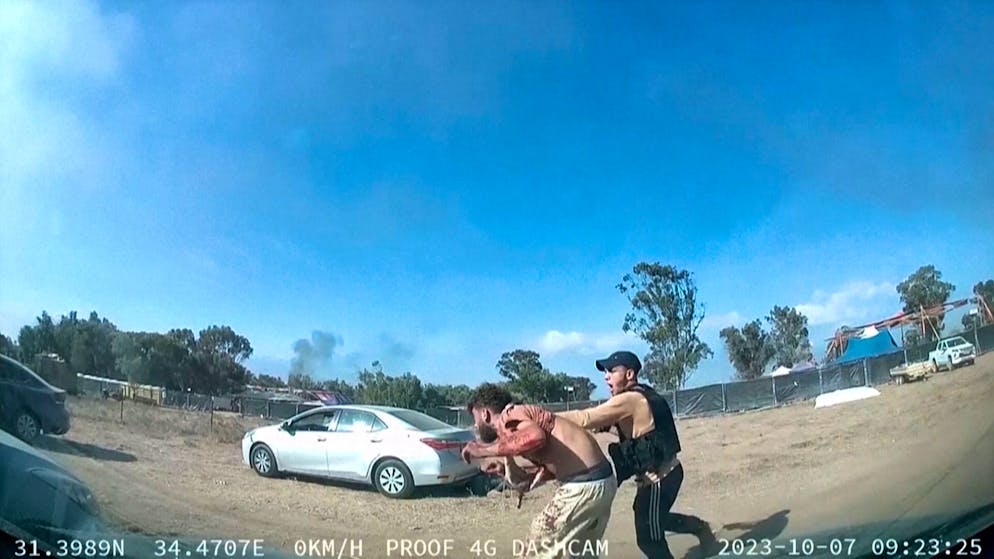 Auf diesem Foto eines Videos attackiert ein bewaffneter Mann von hinten einen blutenden Mann während eines Angriffs von militanten Hamas-Kämpfern auf dem Tribe of Nova Trance Musikfestival in der Nähe des Kibbuz Reim.