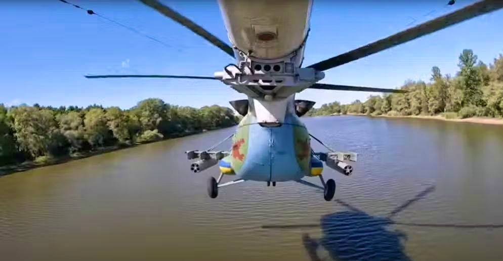 Un Mi-8 segue un fiume in volo basso.