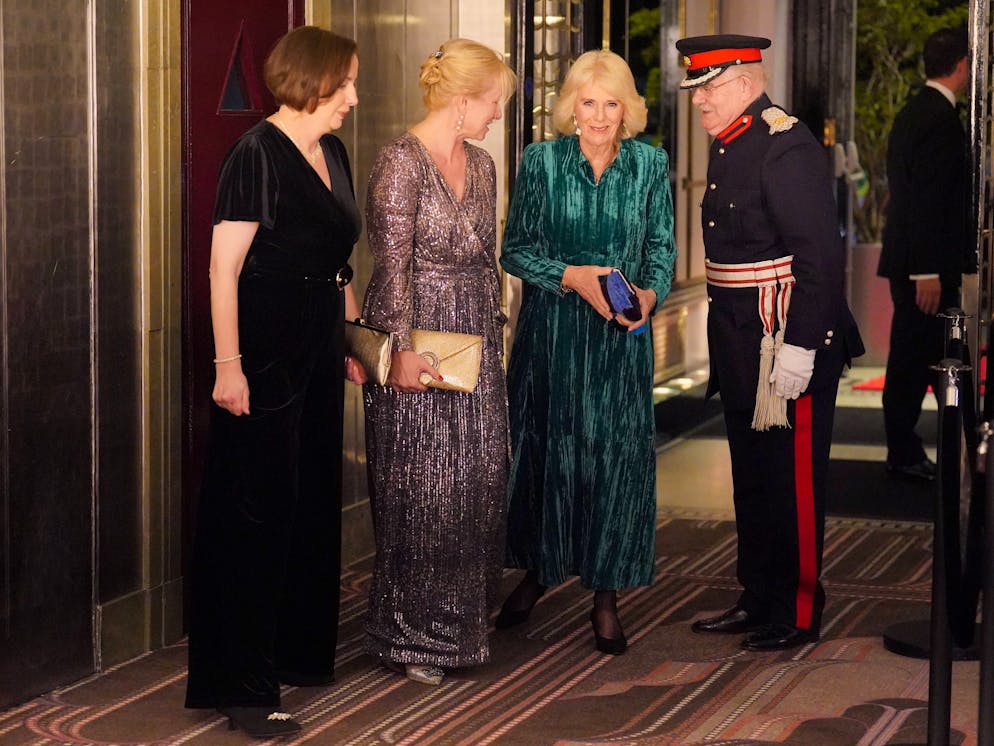 Stile reale: l'abito di velluto di Camilla. Si tratta di un outfit dello stilista londinese ME+EM, impreziosito da un bracciale di smeraldi di Van Cleef & Arpels.