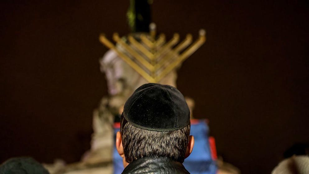 L'Hanukkah è una delle feste ebraiche più importanti ed è celebrata dagli ebrei in tutto il mondo durante otto giorni fino al 14 dicembre. Qui ritratto un uomo con la kippah nel corso di un evento tenutosi ieri sera nella place de la République a Parigi.