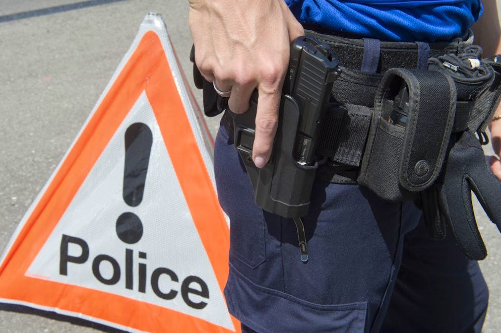 Un policier de la Police cantonale neuchateloise tient son pistolet devant un signe police, le 5 juin 2015, a Neuchatel. (KEYSTONE/Sandro Campardo) 

Ein Polizist der Kantonspolizei Neuenburg greift nach seiner Pistole, am 5. Juni 2015, in Neuenburg. (KEYSTONE/Sandro Campardo)