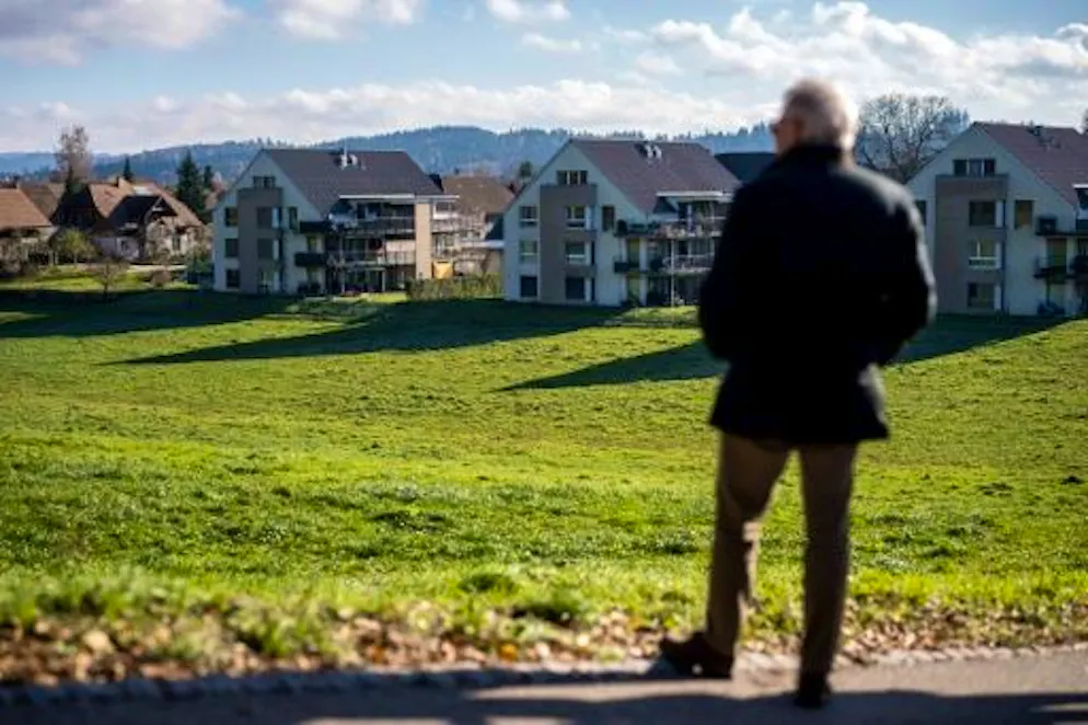 Suisse: le glas va t-il sonner pour les cloches des vaches d'Aarwangen? - Gallery. Le maire d'Aarwanger, Niklaus Lundsgaard-Hansen devant un champ où paissaient des vaches avec leurs cloches à côté d'une zone résidentielle, le 29 novembre 2023 en Suisse