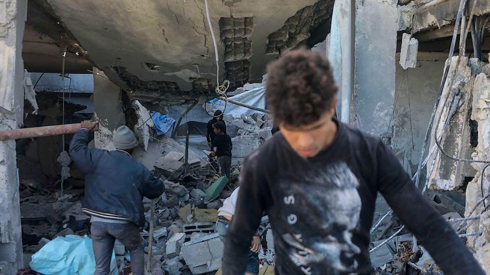 Alcuni palestinesi ispezionano ciò che resta delle loro case dopo gli attacchi israeliani