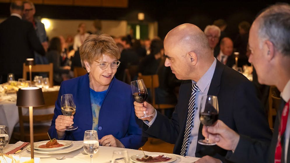 La consigliera federale Viola Amherd (a sinistra) il presidente della Confederazione Alain Berset (al centro) e il presidente del Consiglio di Stato vallesano Christophe Darbellay, brindano alla Simplonhalle ai festeggiamenti per l'elezione a presidente della Confederazione per il 2024 di Amherd