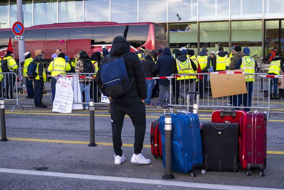 I passeggeri arrivano con i loro bagagli mentre i dipendenti di Dnata de Geneve Aeroport (AIG) scioperano all'Aeroporto Internazionale di Ginevra (AIG) la mattina di domenica 24 dicembre 2023..La società fornisce parte dei servizi di assistenza a terra all'aeroporto di Ginevra. Un accordo tra le parti è stato raggiunto poco prima di mezzogiorno.
