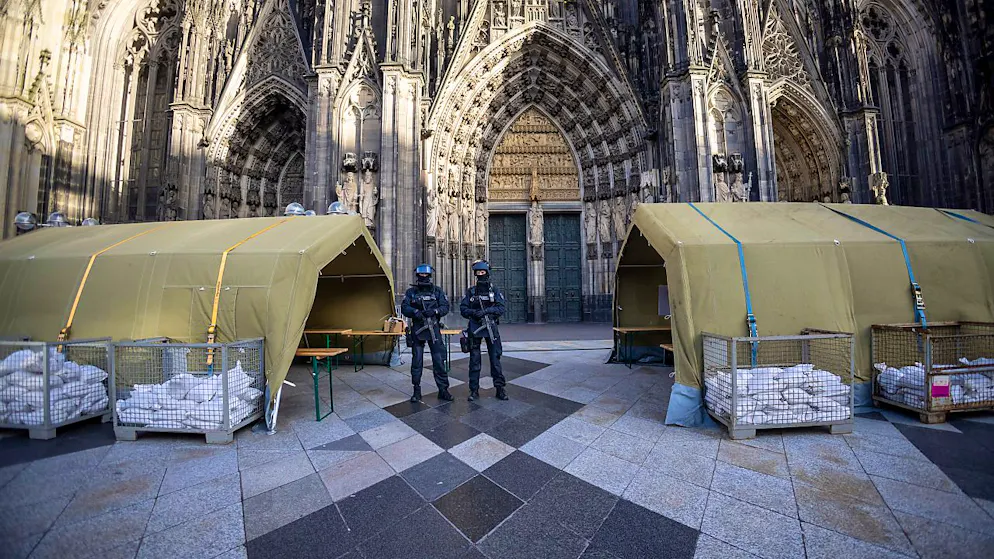 dpatopbilder - Polizisten mit Maschinenpistolen stehen vor dem Kölner Dom. Nach dem Terroralarm für das Gotteshaus sind drei weitere Verdächtige festgesetzt worden. Foto: Thomas Banneyer/dpa