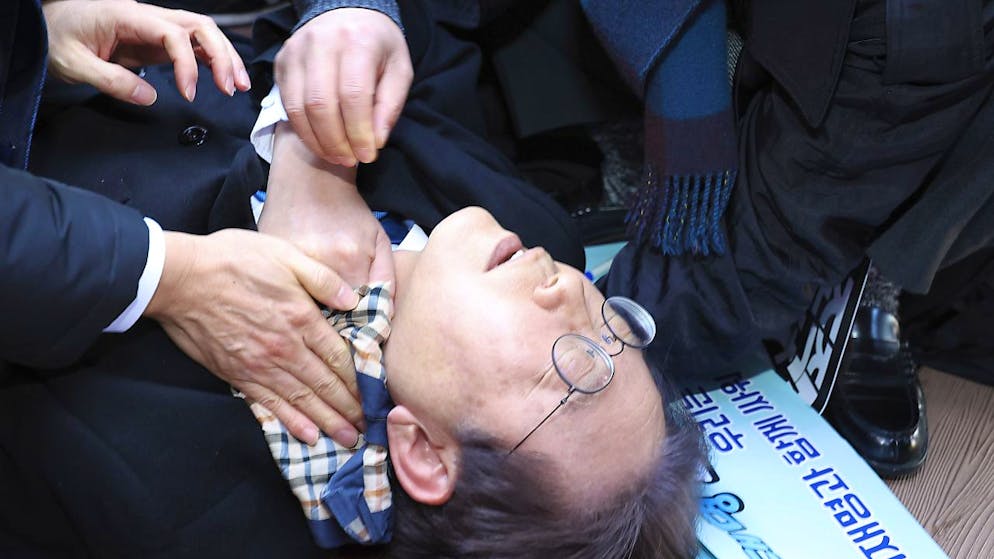 Il leader politico sudcoreano soccorso dai presenti subito dopo l'aggressione.