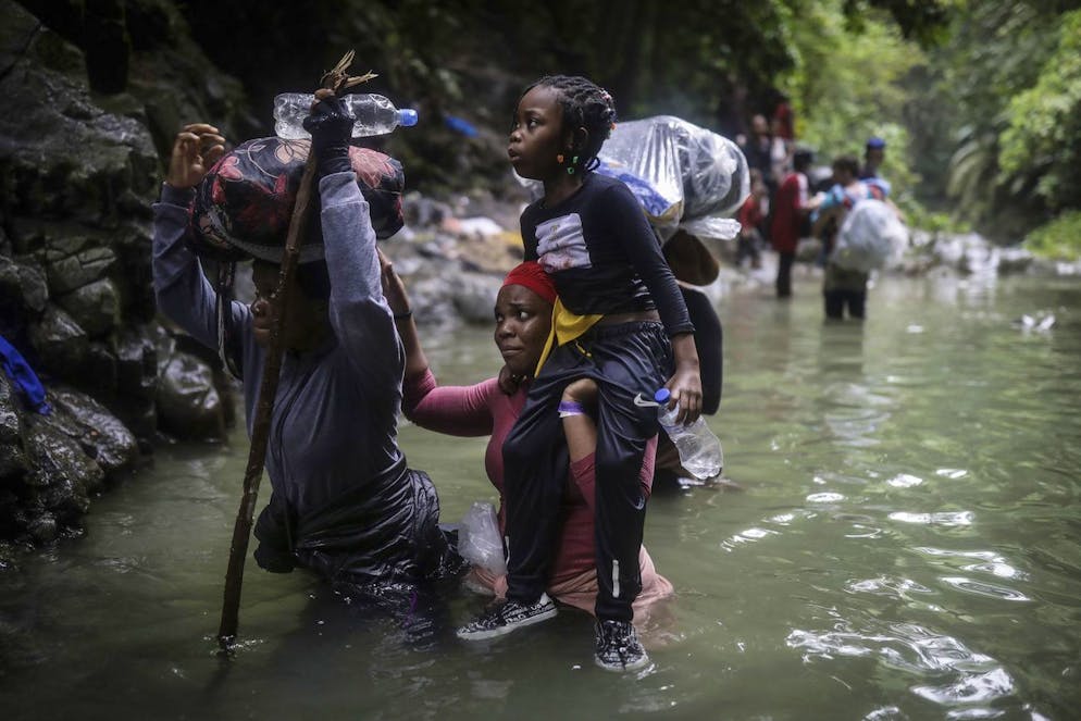 Migranti haitiani guadano un fiume mentre attraversano il Darien Gap dalla Colombia a Panama nella speranza di raggiungere gli Stati Uniti, 9 maggio 2023.
