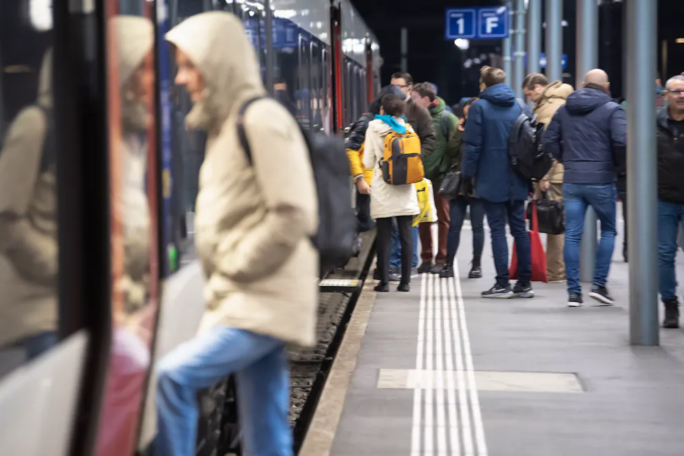 Pendler steigen in einen Zug ein am Bahnhof in Bellinzona am Mittwoch, 6. Dezember 2023. Die Tessiner Pendler gehen beim neuen Fahrplan leer aus. Die SBB lassen ab dem 10. Dezember 31 Personenzuege durch den Gotthard-Basistunnel fahren, jedoch verkehren diese nur am Wochenende. (KEYSTONE/TI-PRESS/Francesca Agosta)
