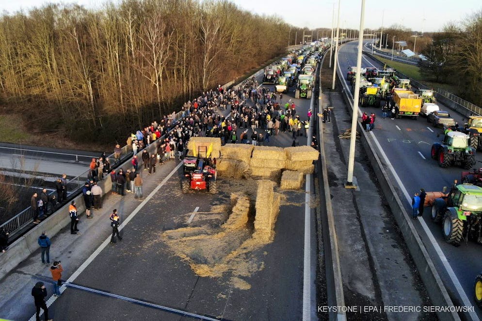 Des agriculteurs bloquent l'autoroute près de Daussoulx, en Belgique, le 28 janvier 2024. Le secteur agricole entend souligner par ces actions la baisse des revenus, la complexité excessive de la législation et la surcharge administrative.