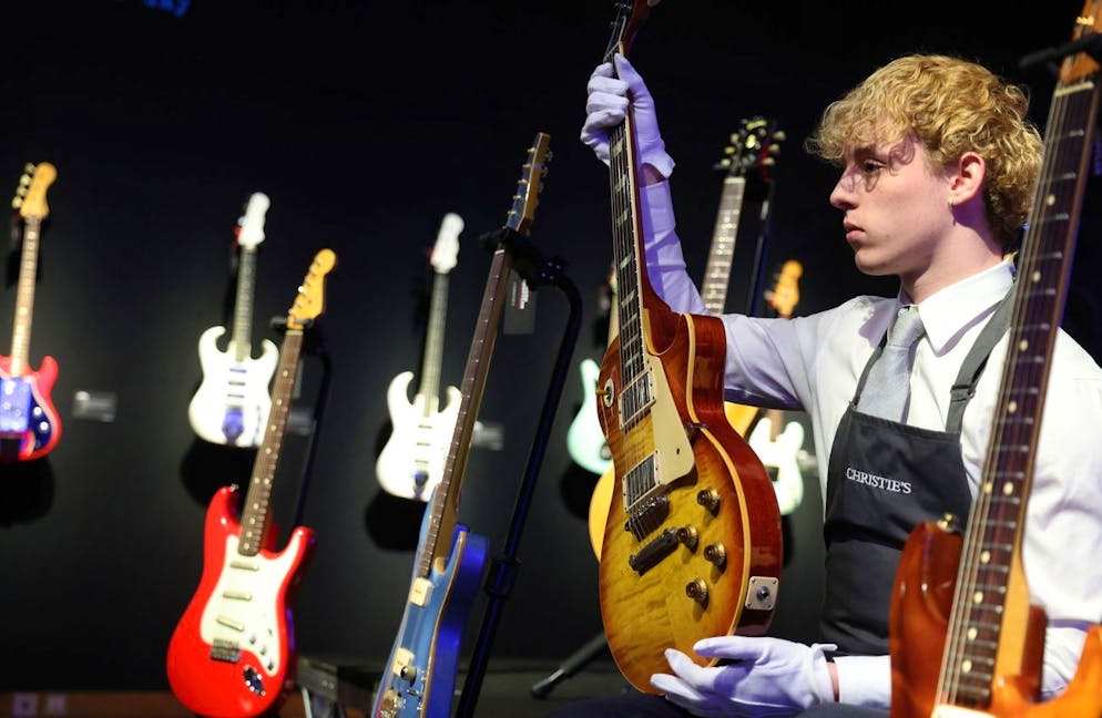 Una chitarra elettrica Gibson Les Paul viene tenuta in mano da un gallerista durante un servizio fotografico per la collezione di chitarre Mark Knopfler alla casa d'aste Christie's a Londra.