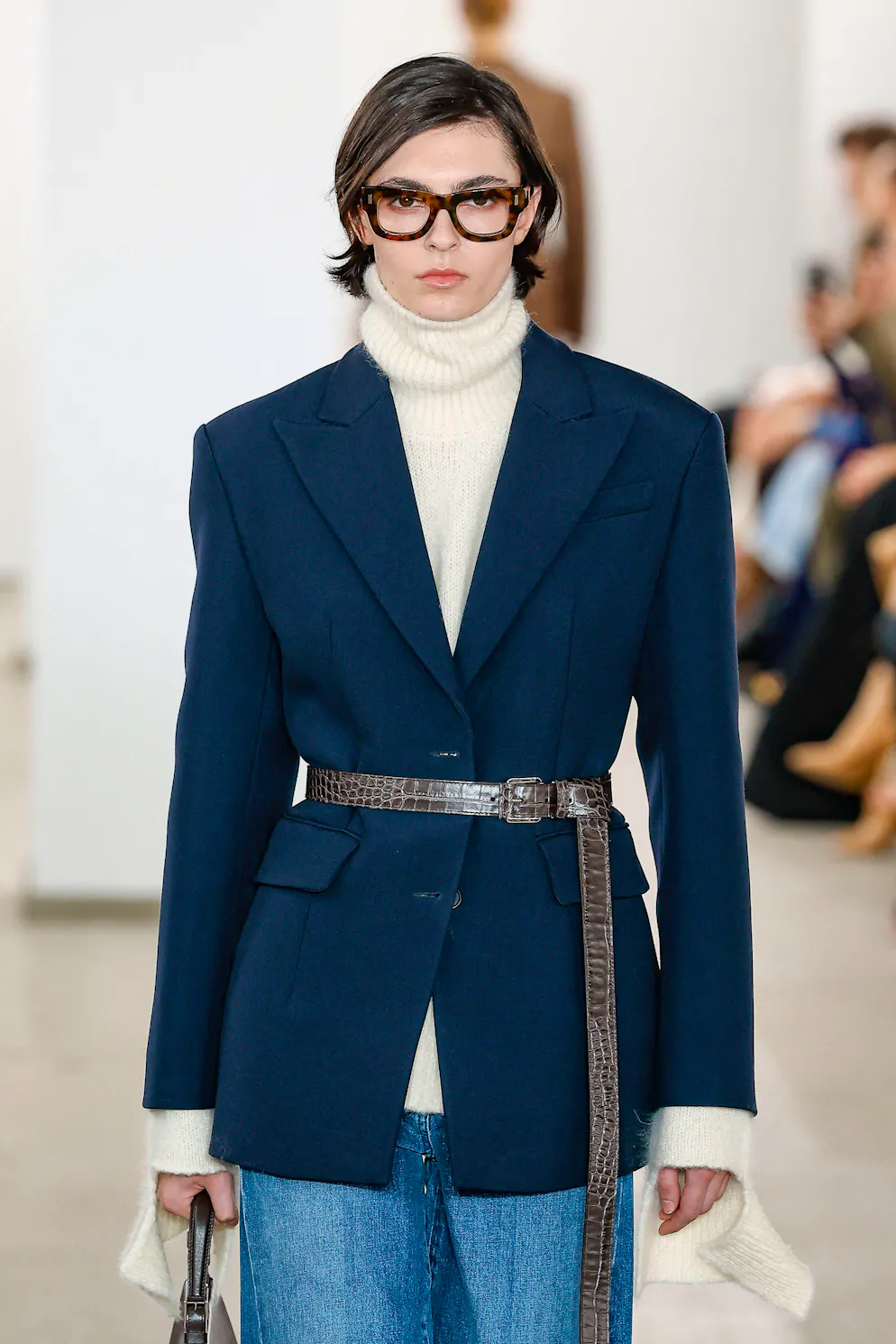 New York Fashion Week: Büro-inspirierter Style. Jeans und Strickpulli zum Blazer: Michael Kors rundet den Look mit einem Taillengürtel ab. 