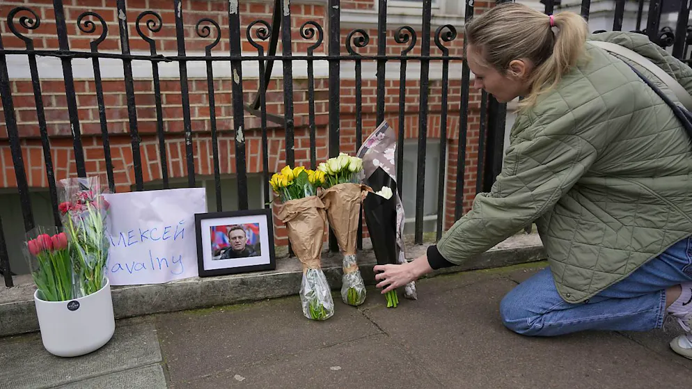 Eine Frau legt gegenüber der russischen Botschaft in London Blumen nieder. Foto: Kin Cheung/AP/dpa