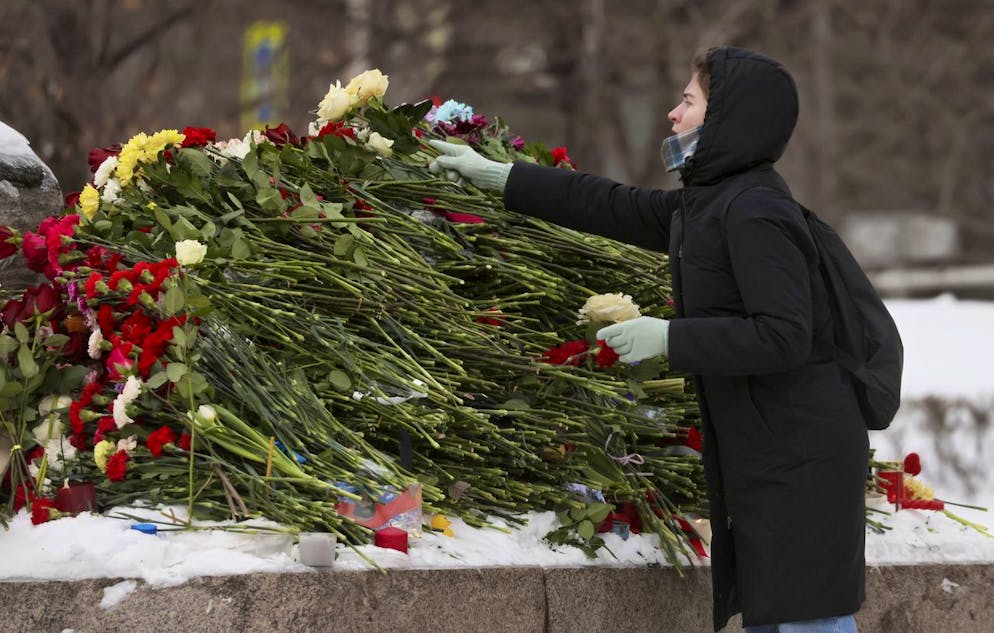 Una donna depone dei fiori in segno di lutto per la morte del leader dell'opposizione russa Alexei Navalny vicino al monumento ai prigionieri politici a Mosca, Russia, 17 febbraio 2024.