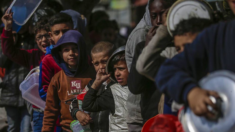Des enfants palestiniens déplacés font la queue dans l'espoir de recevoir de la nourriture de donateurs arabes et palestiniens à Deir Al Balah, dans le sud de la bande de Gaza assiégée.