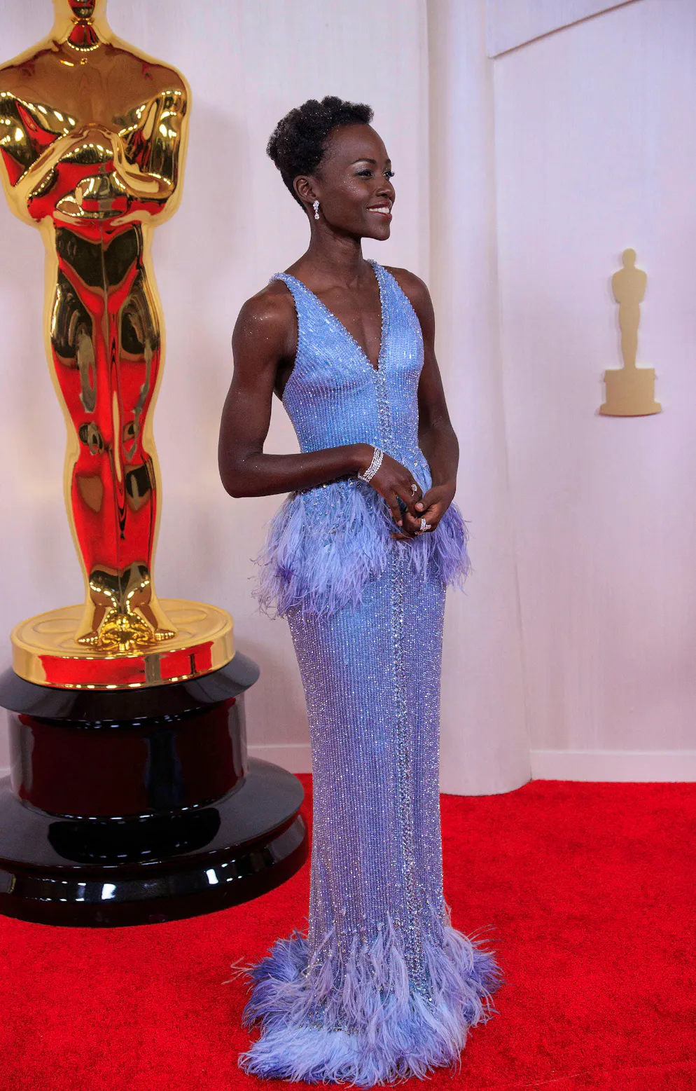 Oscars 2024: Die aussergewöhnlichsten Looks vom roten Teppich. Eine weitere Glamour-Queen in Blau: Lupita Nyong'o in einer glänzenden Robe mit Feder-Details von Giorgio Armani Privé.