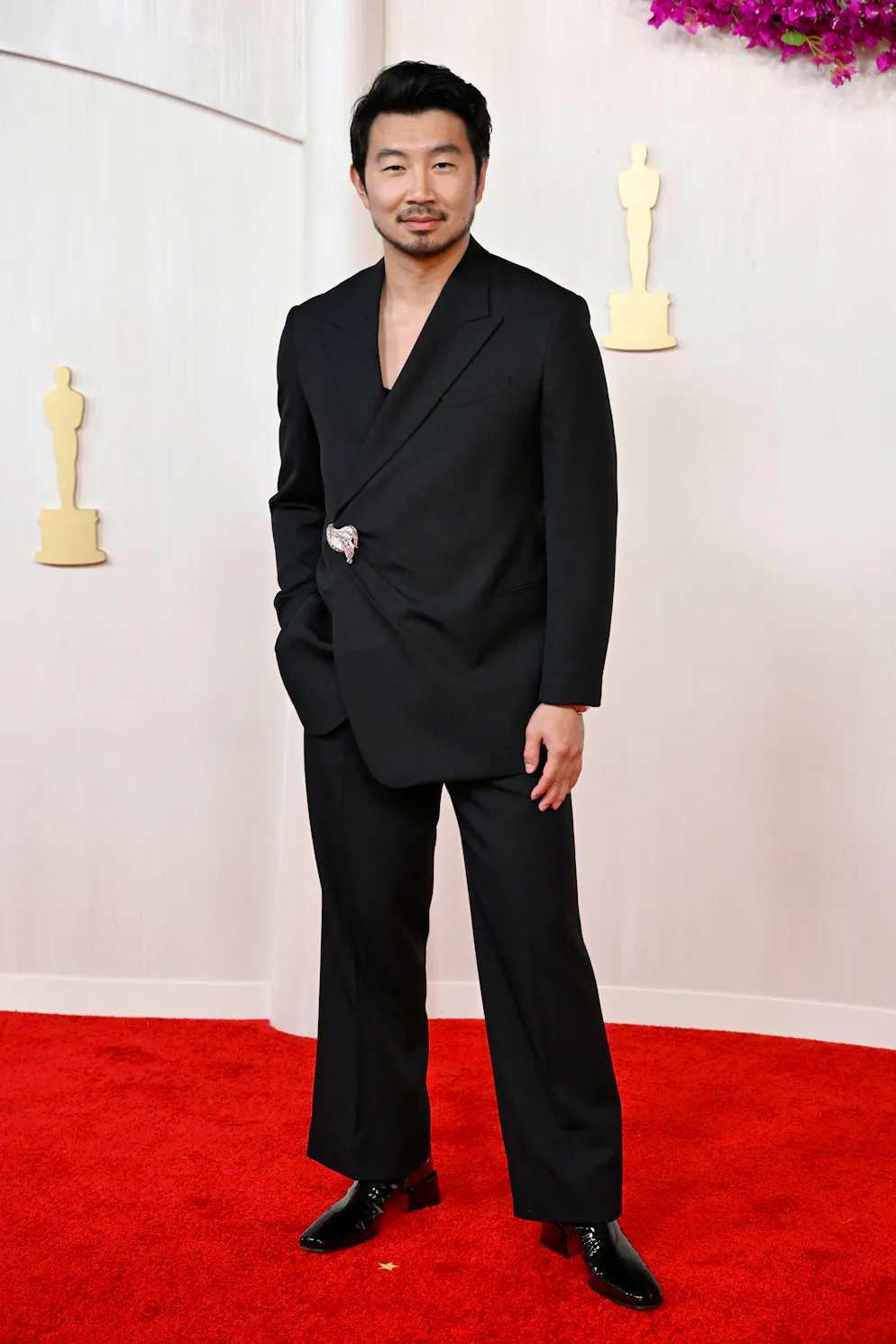 Oscars 2024: Die aussergewöhnlichsten Looks vom roten Teppich. «Ken»-Darsteller Simu Liu kreuzt ohne Hemd im schlichten Fendi-Anzug auf, macht aber unter den männlichen Gästen einen der besten Auftritten. Das Augenmerk liegt auf der Silber-Brosche.