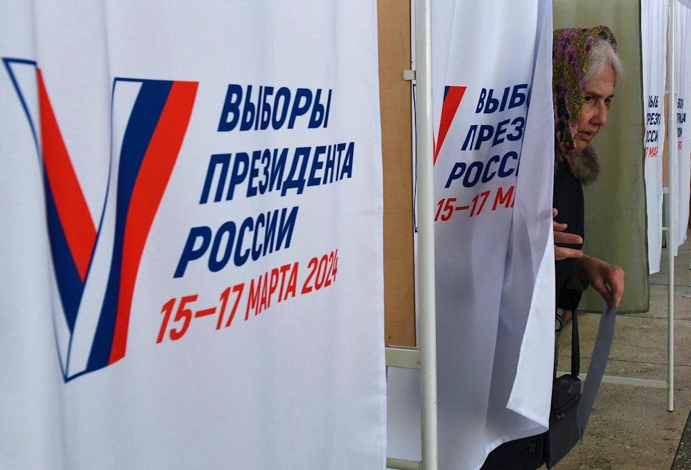 Une femme sort de l'isoloir d'un bureau de vote dans le cadre de l'élection présidentielle russe.