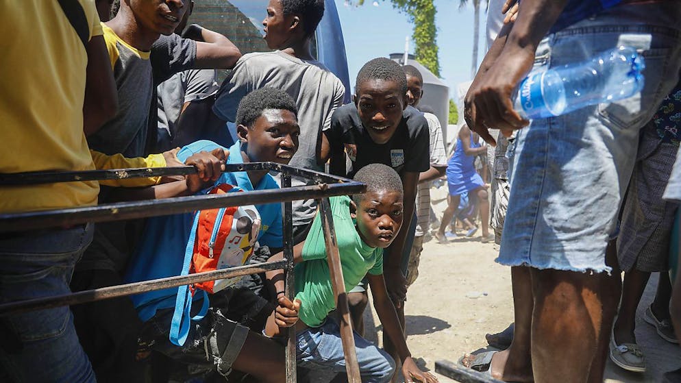 Des enfants se mettent à l'abri de tirs à Port-au-Prince.