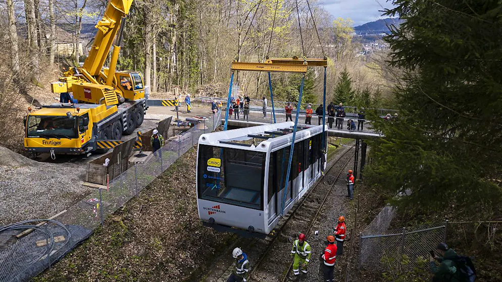 Neue Wagen der Gurtenbahn auf die Schienen gesetzt - Gallery. Ein Kran hob die Wagen von der Strasse und liess sie langsam auf die Bahntrasse nieder.